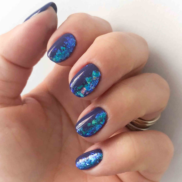 Blue nail art flakes over blue purple gel